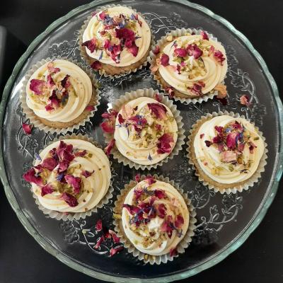 Decorated with vanilla flavoured buttercream, chopped pistachio nuts and edible dried rose petals.